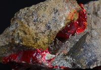 Stein mit verschiedenen Farben, besonders auffallend ein dunkles Rot.