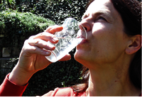 A woman drinking water from a glass.