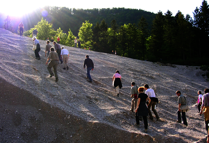 Eine Gruppe von Personen steigt eine Schotterwand hinauf