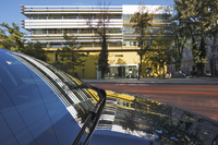 Ein Auto im Vordergrund in dem sich das Gebäude der Geologischen Bundesanstalt, das im Hintergrund ist, spiegelt.