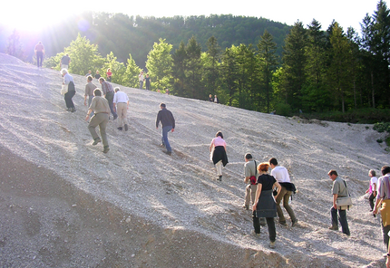 A group of people go up a dirt wall.